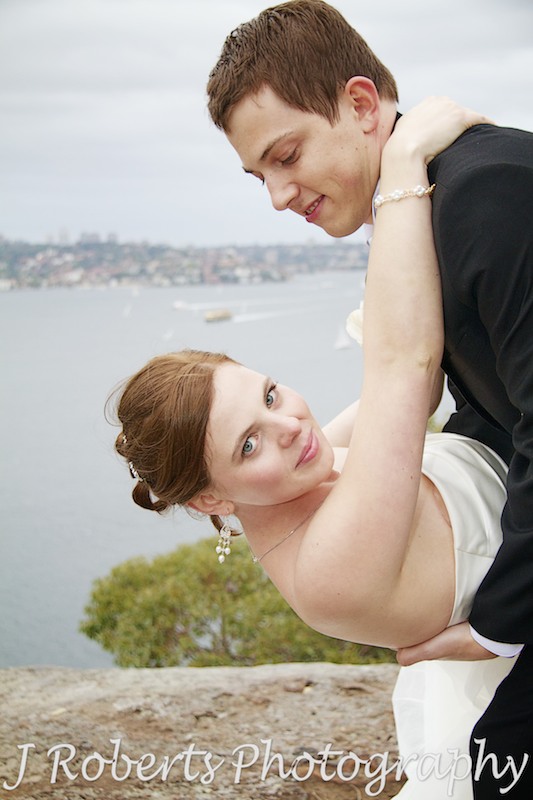 Bride being dipped by the groom with Sydney Harbour in the background - wedding photography sydney